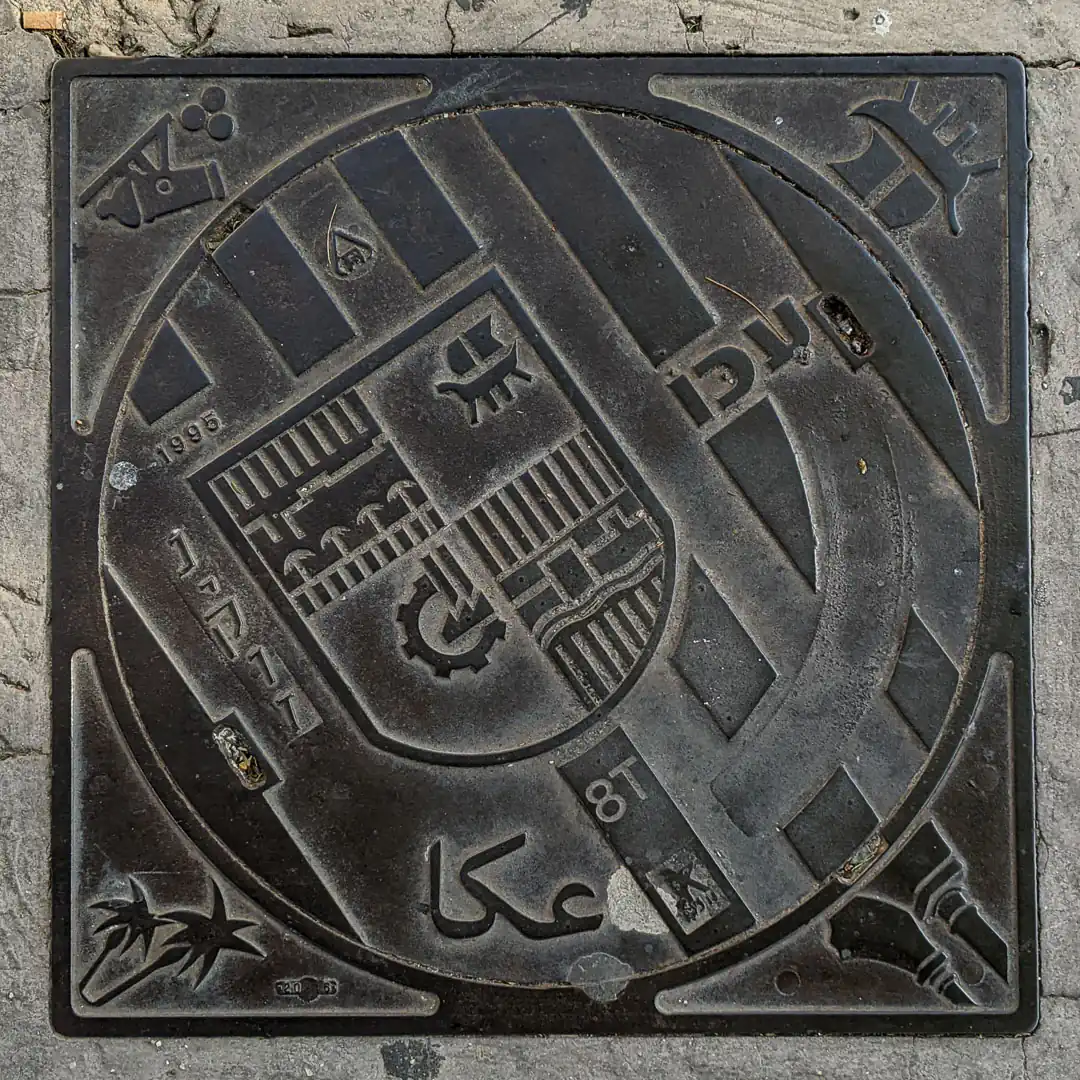 Acre Coat of Arms Manhole Cover in Acre, Israel. Photo by Yuri Matrosovich