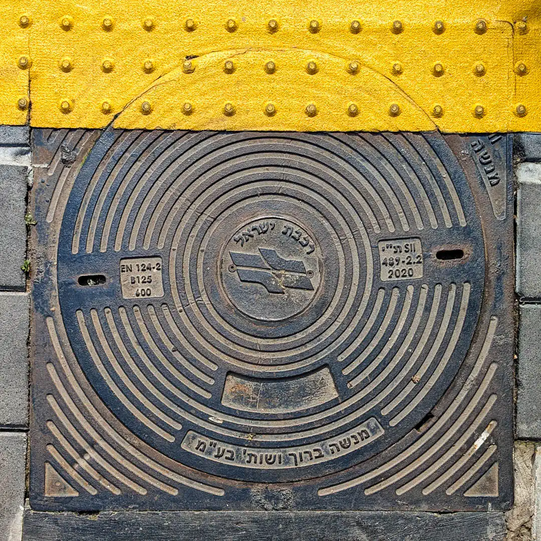 Israel Railways Logo Manhole Cover in Haifa, Israel. Photo by Yuri Matrosovich